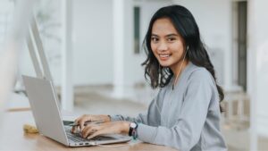 Girl typing on laptop learning about investing